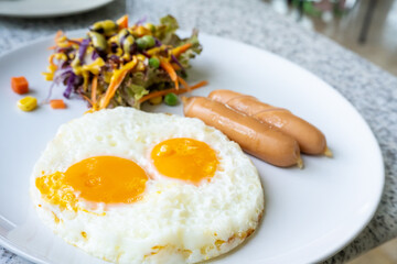 fried eggs with sausage and salad