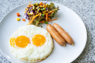 fried eggs with sausage and salad