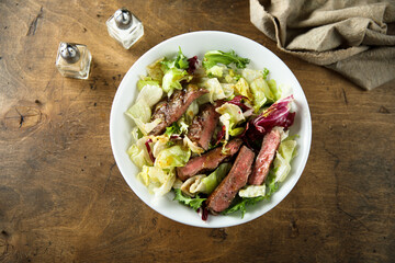 Green salad with beef steak and mustard dressing