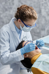 Vertical portrait of female dentist wearing mask during examination in dental clinic