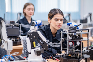 Obraz na płótnie Canvas Mechanical engineers with robotic welder., Programming development technology work. Female industrial engineer working at automated AI robotic production factory