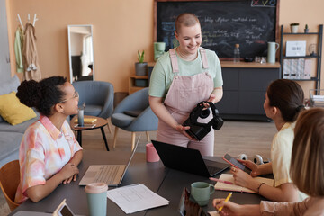 Portrait of smiling bald woman presenting VR project to all female business team in meeting