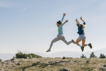 Sexy happy girls having fun on top of the mountain