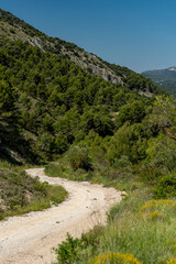 Fototapeta na wymiar Small gravel mountain road passing over a mountain range, Costa Blanca, Alicante, Spain