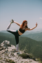 Girl doing yoga at the mountain