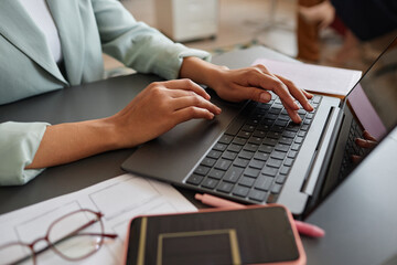 Fototapeta na wymiar Closeup of elegant black businesswoman using laptop while working in successful career in office, copy space