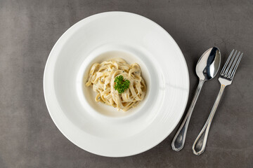 Freshly made fettucini alfredo on a white porcelain plate