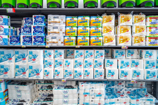 Italy - June 22, 2023: Packs of toilet paper and hand paper towel roll on shelves for sale in Italian supermarket
