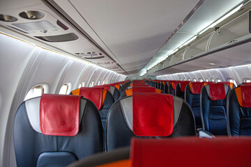 Empty cabin of the plane. Soft seats for passengers, portholes. Inside a passenger plane seat....