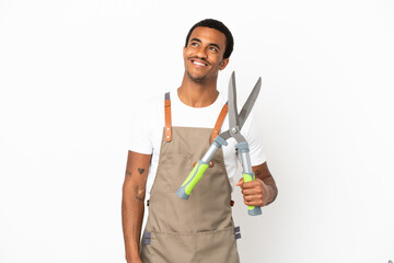 African American gardener man holding pruning shears over isolated white background thinking an idea while looking up