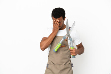 African American gardener man holding pruning shears over isolated white background with tired and sick expression