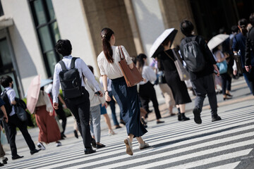 丸の内で働く女性の朝、出勤する後ろ姿
