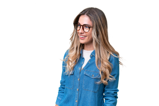 Young Uruguayan woman over isolated background looking to the side and smiling