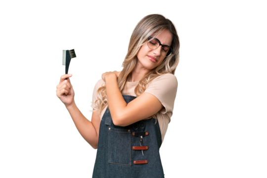 Young Uruguayan hairdresser woman over isolated background suffering from pain in shoulder for having made an effort