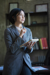 Portrait of an Asian businesswoman thinking and looking away.