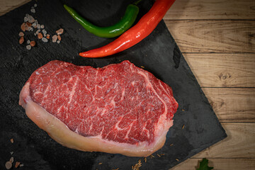 Raw hanging tender or onglet steak of beef on wooden Board with rosemary and thyme on wooden background