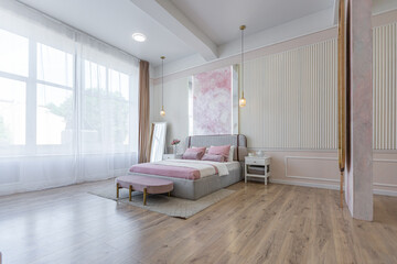 modern cozy soft interior design of a room with a bedroom and a home office in warm delicate pastel...