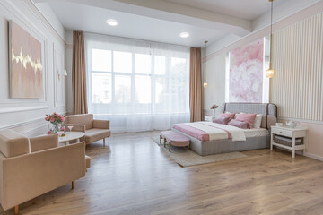 modern cozy soft interior design of a room with a bedroom and a home office in warm delicate pastel pink and beige colors