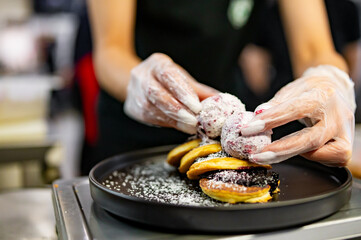 woman chef hand cooking pancakes with blueberry jam and ice cream on kitchen