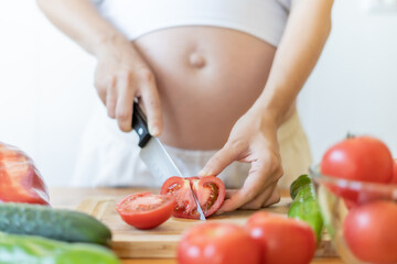 PREGNANT WOMAN CHOPPING VEGETABLES