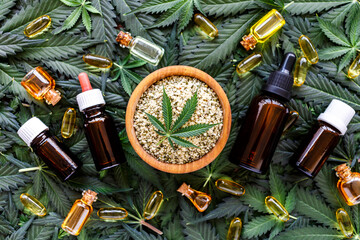 Hemp cannabis leaves and beauty products.Marijuana extract in cosmetology.Wild hemp oil, leaves and seeds.Legalized cannabis for skincare products. - obrazy, fototapety, plakaty