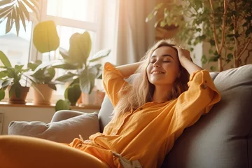 Fotobehang Happy woman relaxing on the sofa at home - Smiling girl enjoying day off lying on the couch, Healthy life style, good vibes people and new home concept © Banana Images