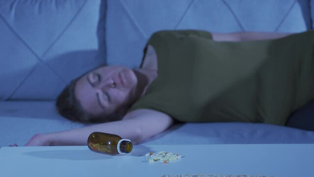 The woman who looks at the pills in her hand and is going to commit suicide.