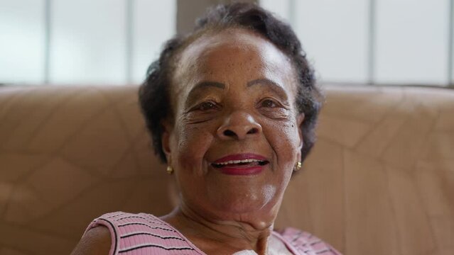 One happy black elderly woman smiling. Close-up face portrait of an African American older lady looking at camera