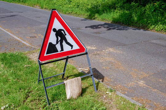 Road works warning sign on quiet country lane. Road maintenance ahead caution sign 