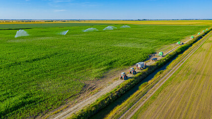 Aerial view on high pressure agricultural water sprinkler, sprayer, sending out jets of water to...