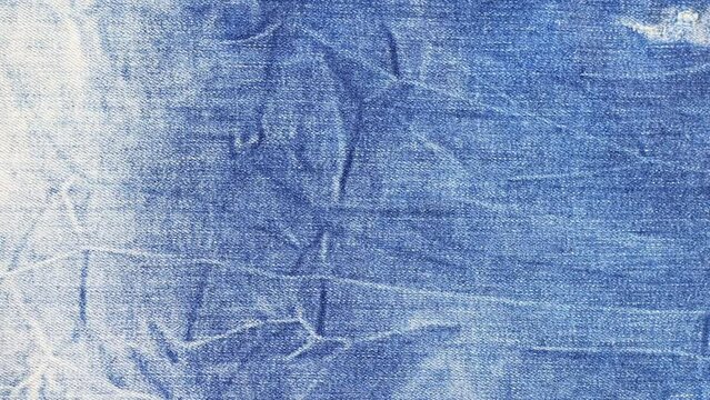 Crinkled denim textile background. Slow motion.