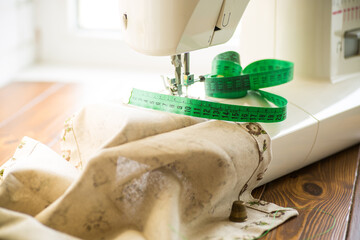 Sewing machine with fabric and threads for sewing, close-up. The working process
