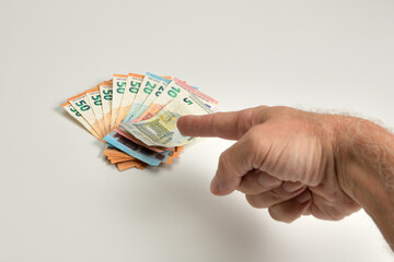mano señalando al dinero como símbolo de poder
