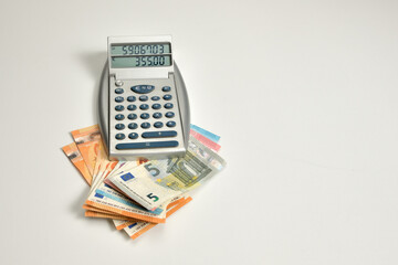 calculadora con dinero en efectivo debajo de ella 