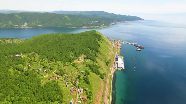 View of Lake Baikal, the village, the port at the source of the Angara River on a sunny summer day.