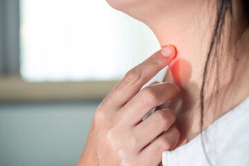 Close up woman scratch the neck by hand at home, due to itching in the throat, throat infection, flu, irritation. Healthcare and medical concept.