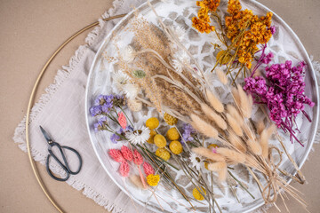 Farbenfrohe Trockenblumen auf einem Teller, getrocknete Blumen wie Lagurus, Strandflieder, Hirse,...