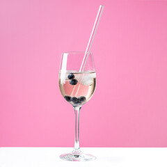 Sommergetränk, Lillet, wild Berry, Getränk im Sommer mit Strohhalm aus Glas, vor rosa, pink Hintergrund.