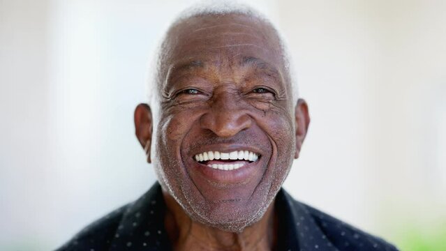 One happy friendly black senior man close-up face laughing and smiling. Portrait of a joyful African American male person in 70s