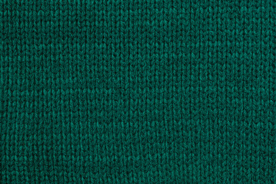Texture of green woolen fabric, knitted texture of clothes, close-up view
