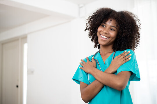 Embrace equity on multiracial Internal Women's Day. Photo of Africa American pretty cheerful nurse folded crossed arms beaming smile at home clinic