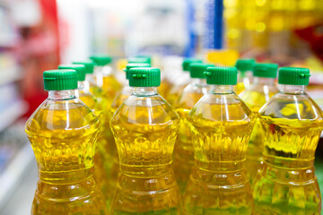 Plastic bottles of sunflower oil on shelf in supermarket, closeup