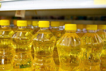 Plastic bottles of sunflower oil on shelf in supermarket, closeup