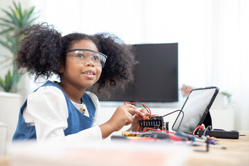 African American girls determined and serious to making and fixing electrical robot car and...