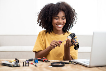 African American learning at home in coding robot cars and electronic board cables in STEM, STEAM,...