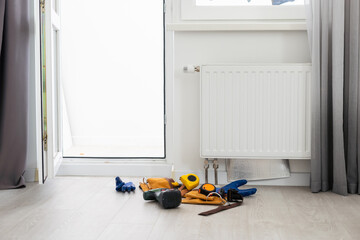 Central heating radiator with handyman tools for fixing home system, gas crisis and seasonal issues.