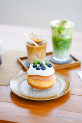 Delicious doughnut in plate with glass of ice coffee and ice matcha green tea at cafe.