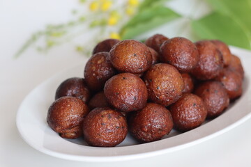 Unniyappam. Delicious sweet rice fritters made with a batter of rice, banana, jaggery, ghee fried coconut pieces, black sesame seeds and flavored with cardamom