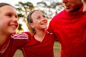 Close-up of female tween football team players in a huddle preparing for a game