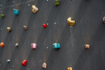 Grey wall with climbing holds in park